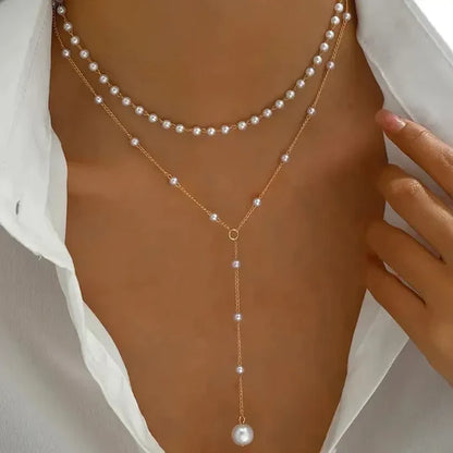 Double-strand necklace with pearls and pendants.